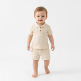Conjunto polo acanalado de algodón para bebé (polera + short) color crema / marfil